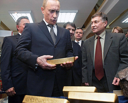 Putin holding a gold bar re why is Russia buyign Gold?